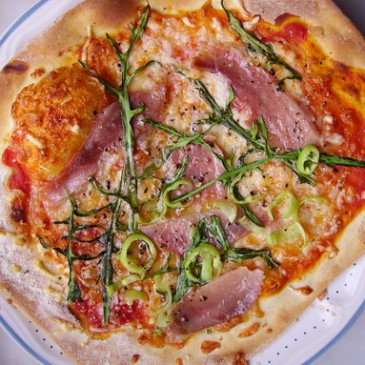 Pizza met ham, rucola en chilis